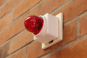 Image showing Red emergency light on a brick wall