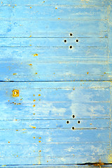 Image showing stripped paint in  blue wood door  rusty nail