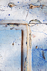 Image showing stripped paint in   wood door and rusty nail