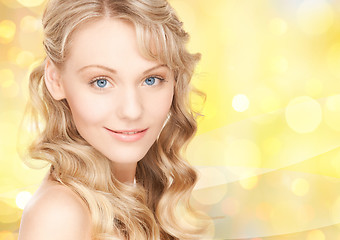 Image showing beautiful young woman face over yellow lights