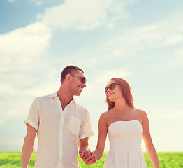 Image showing smiling couple in sunglasses walking outdoors