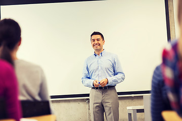 Image showing group of students and smiling teacher in classroom