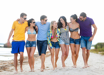 Image showing group of happy friends walking along beach