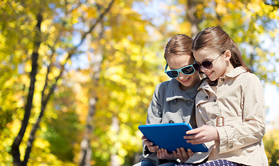 Image showing happy girls with tablet pc computer outdoors