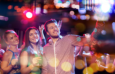 Image showing friends taking selfie by smartphone in night club