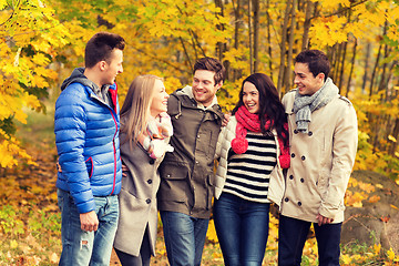 Image showing group of smiling men and women in autumn park