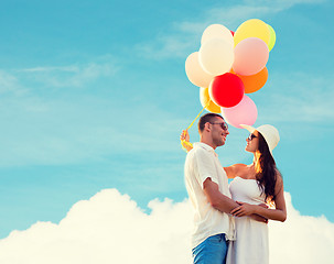 Image showing smiling couple with air balloons outdoors