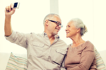 Image showing happy senior couple with camera at home