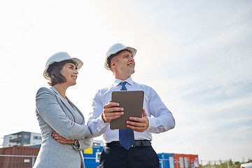 Image showing happy builders in hardhats with tablet pc outdoors