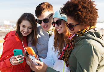 Image showing smiling friends with smartphones