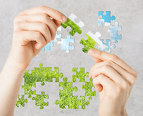 Image showing hands trying to connect puzzle pieces