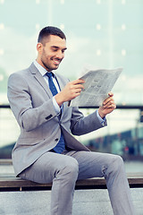 Image showing young smiling businessman newspaper outdoors