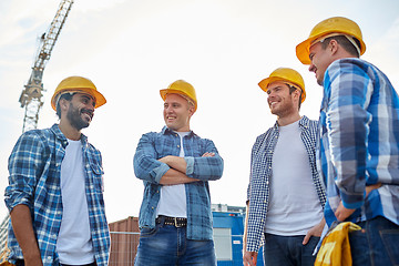 Image showing group of smiling builders in hardhats outdoors