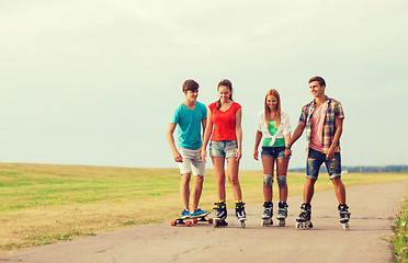 Image showing group of smiling teenagers with roller-skates