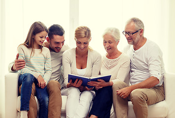 Image showing happy family with book or photo album at home