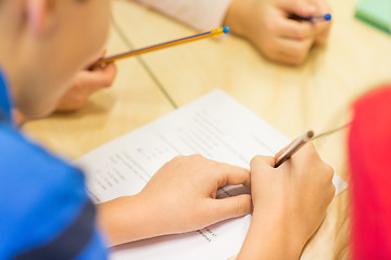 Image showing close up of schoolboy writing test at school