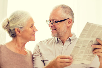 Image showing happy senior couple reading newspaper at home