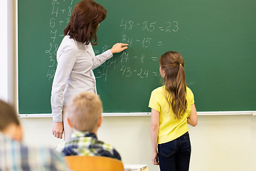 Image showing schoolgirl and teacher with task on chalk board