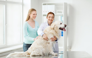 Image showing happy woman with dog and doctor at vet clinic