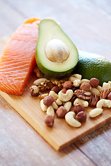 Image showing close up of salmon, avocado and nuts on table