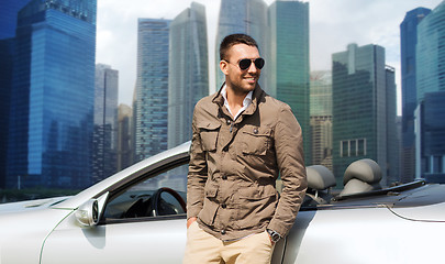 Image showing happy man near cabriolet car over city background