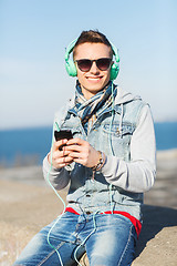 Image showing happy young man in headphones with smartphone