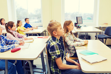 Image showing group of school kids with notebooks in classroom