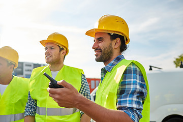 Image showing happy male builders in vests with walkie talkie