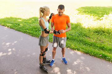 Image showing happy couple with roller skates riding outdoors