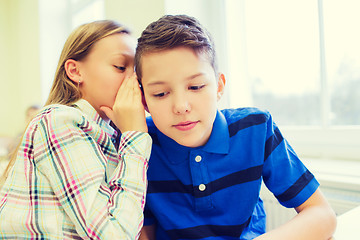 Image showing smiling schoolgirl whispering to classmate ear