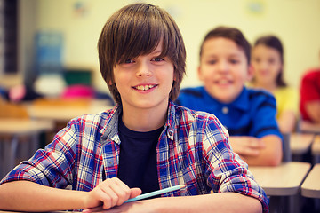 Image showing group of school kids with notebooks in classroom