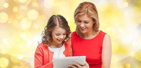 Image showing mother and daughter with tablet pc over lights