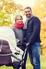 Image showing smiling couple with baby pram in autumn park