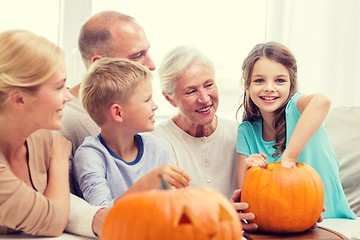 Image showing happy family sitting with pumpkins at home