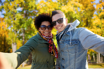 Image showing happy teenage couple taking selfie on city street