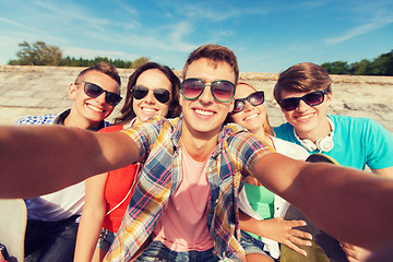 Image showing group of smiling friends making selfie outdoors