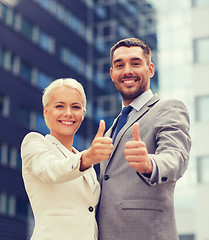 Image showing smiling businessmen showing thumbs up