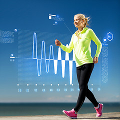 Image showing smiling woman doing sports outdoors with earphones