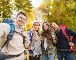 Image showing group of smiling friends with backpacks hiking