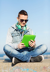 Image showing happy young man with tablet pc and headphones