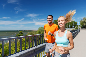 Image showing smiling couple running at summer seaside