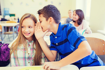 Image showing smiling schoolboy whispering to classmate ear