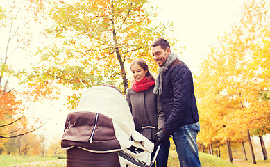 Image showing smiling couple with baby pram in autumn park