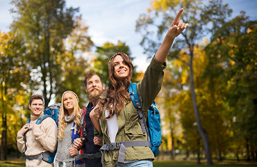 Image showing group of smiling friends with backpacks hiking