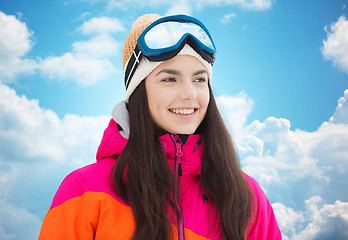 Image showing happy young woman in ski goggles over blue sky