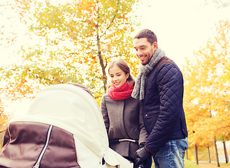 Image showing smiling couple with baby pram in autumn park