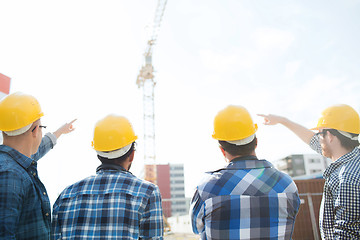 Image showing group of builders in hardhats at construction site