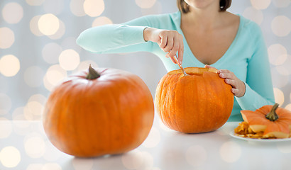 Image showing close up of woman carving pumpkins for halloween