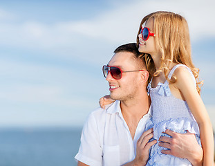 Image showing happy father and child in sunglasses over blue sky