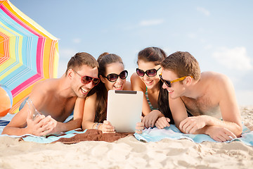 Image showing happy friends with tablet pc on beach